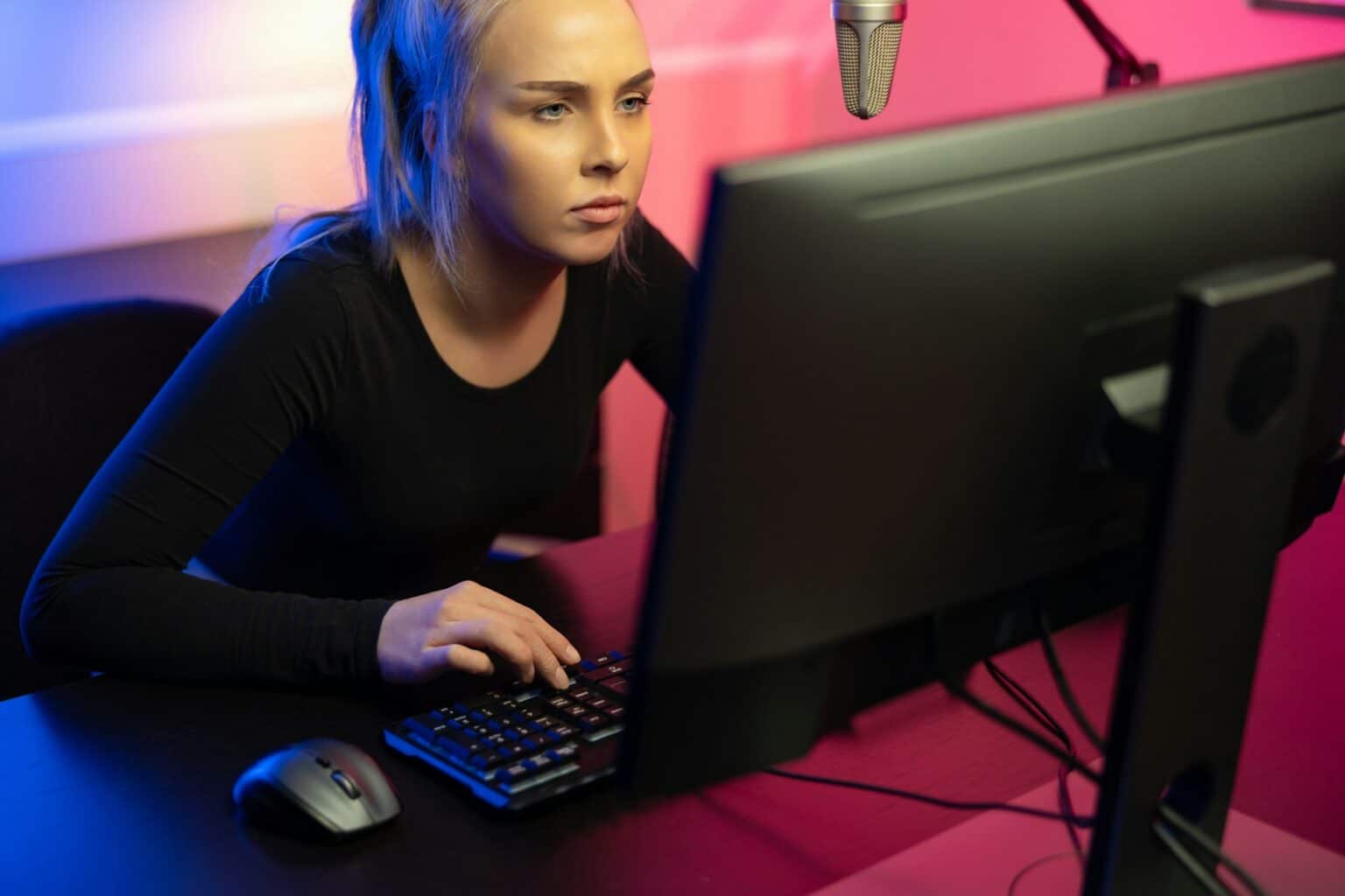 Les jeux vidéo d’action améliorent les compétences visuomotrices nécessaires à la conduite Focused Professional E-sport Gamer Girl with Headset Playing Online Video Game on PC