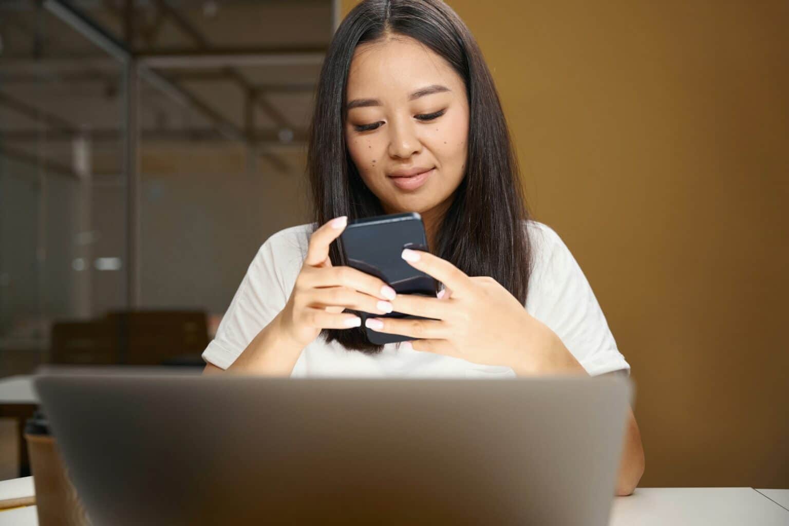Comment créer une adresse email professionnelle gratuite : les étapes clés Asian entrepreneur with mobile phone is reading email in conference room