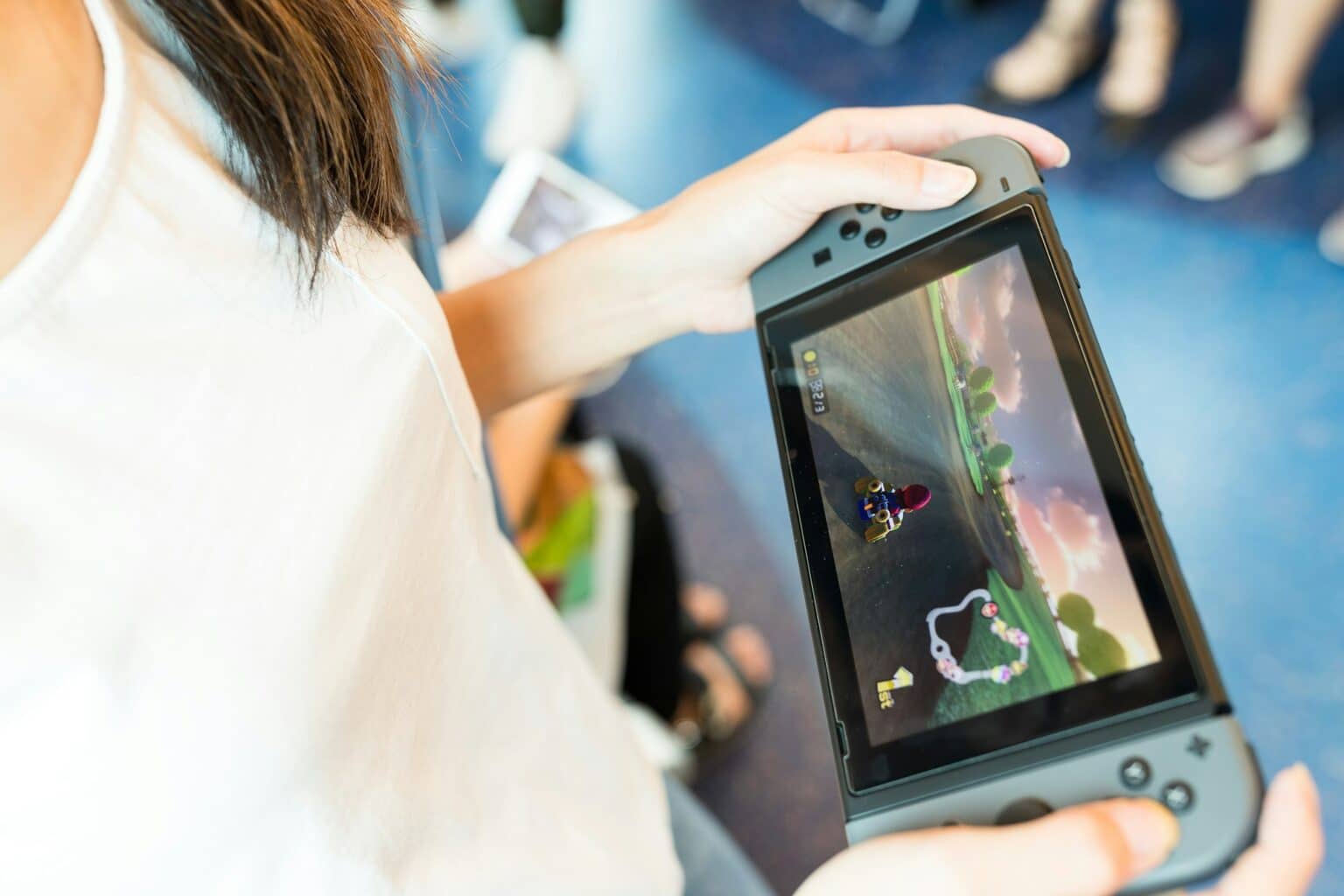 Nintendo Switch 2 : Sa date de lancement et ses caractéristiques ? Woman holding a Nintendo Switch video game system