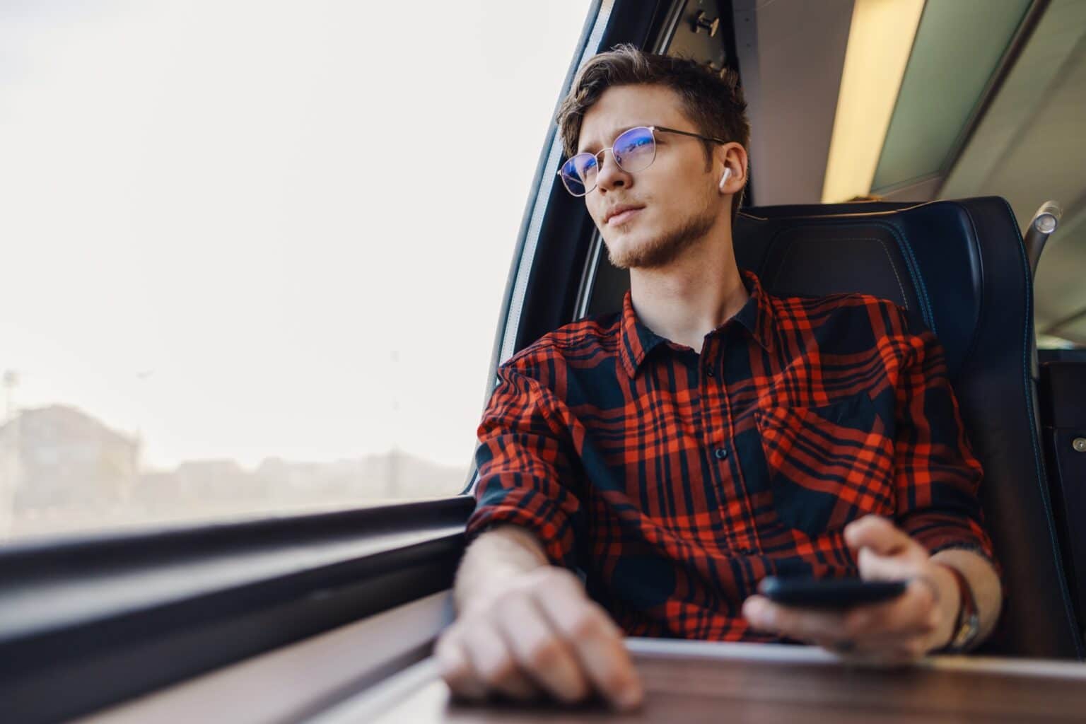 Télécharger SNCF Connect : compagnon digital de millions d’utilisateurs A passenger in train is listening music and looking trough train window