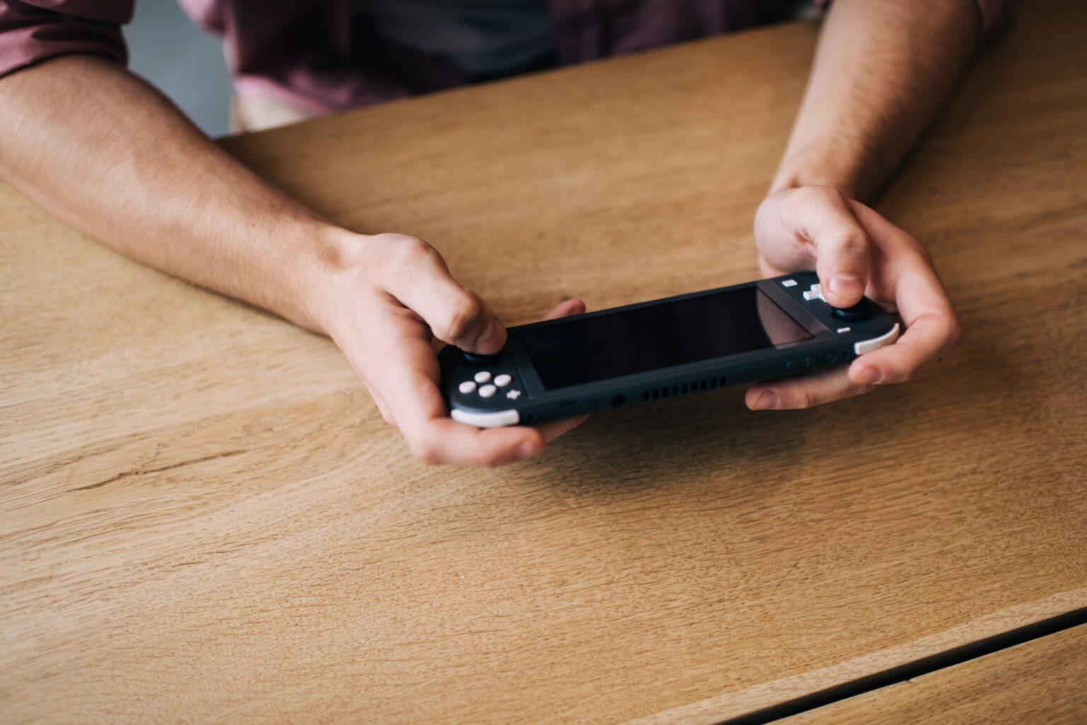 Nintendo Switch : que faire face aux pannes avec des écrans de couleur ? Cropped man holding digital joypad press handheld buttons for win virtual 3s game,