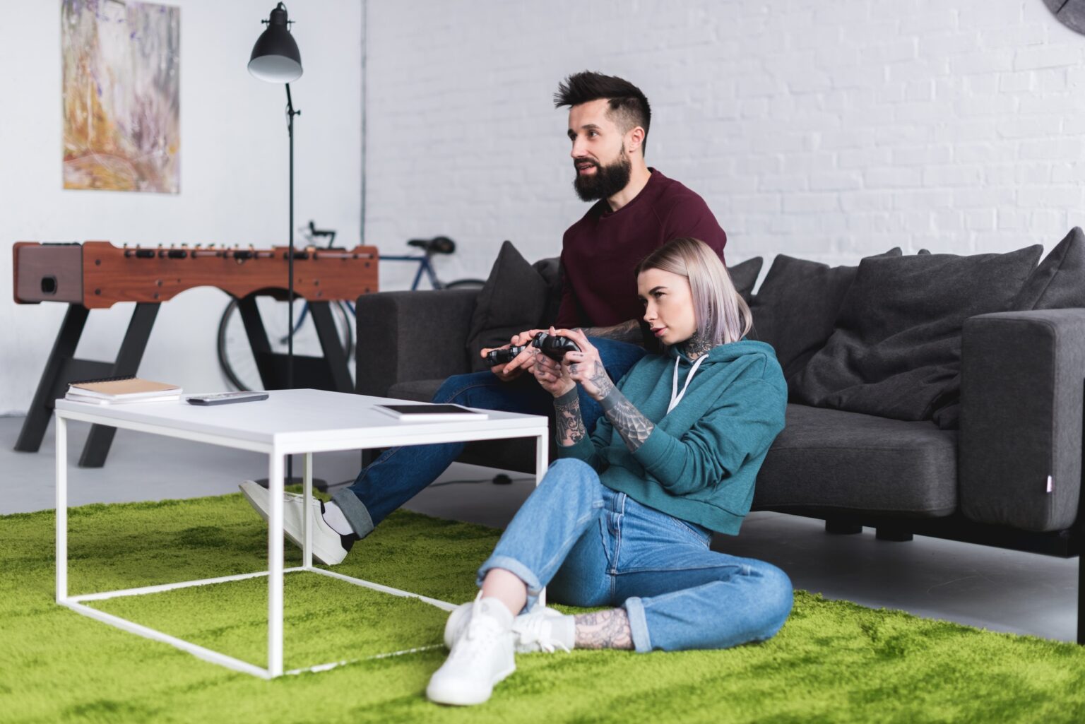 EA Sports FC 24 : Laquelle des Éditions Choisir pour Votre Expérience Optimale tattooed couple playing video game in living room