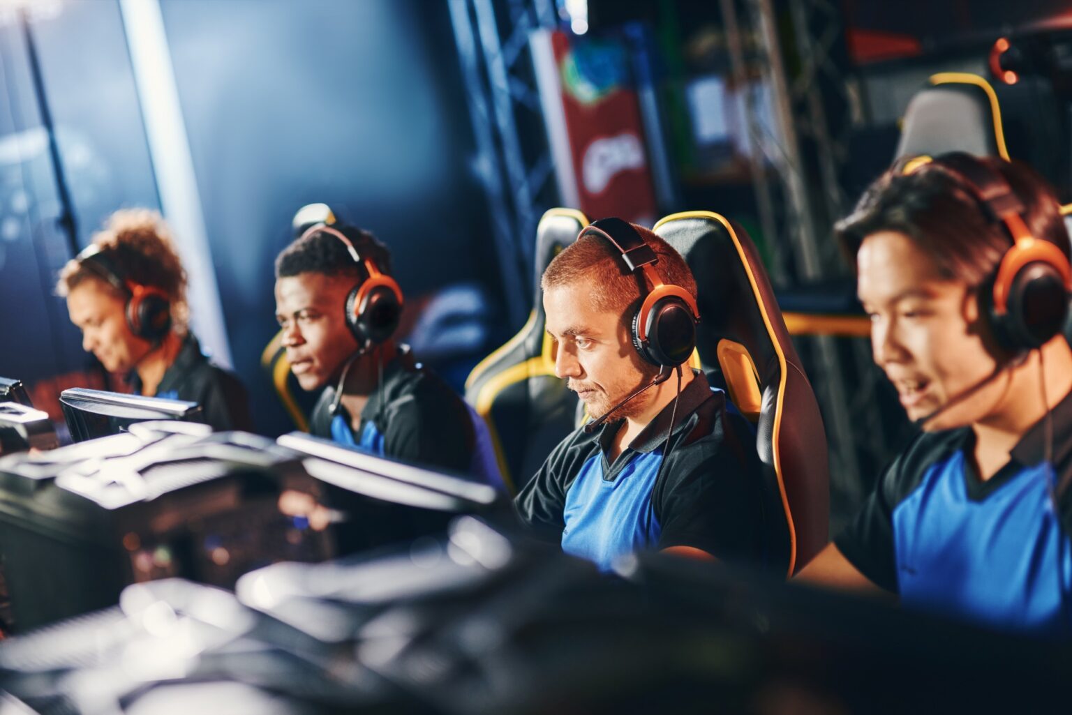 Team of four professional cybersport gamers wearing headphones