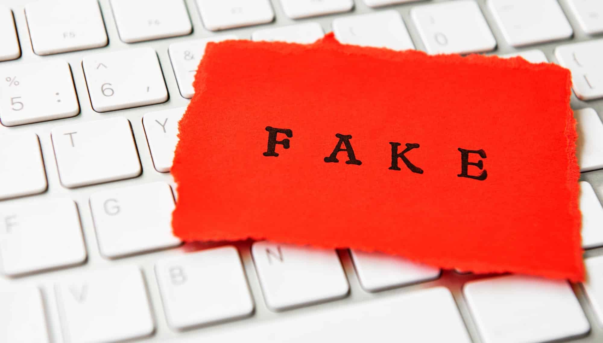 Word Fake written on torn paper
