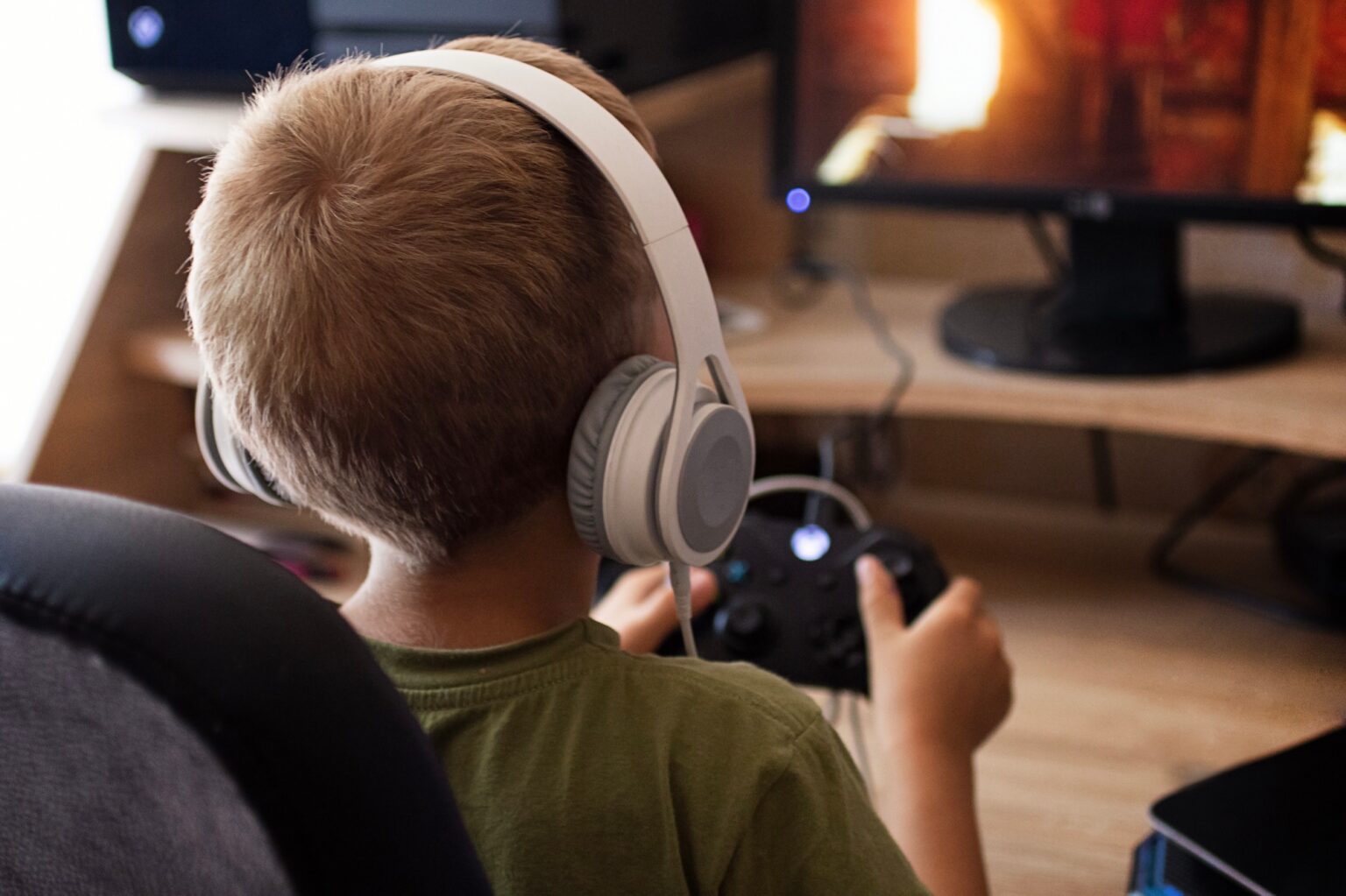 La formule Xbox Game Pass Standard : prix et présentation de cette offre Child in headphones playing with joystick x-box.
