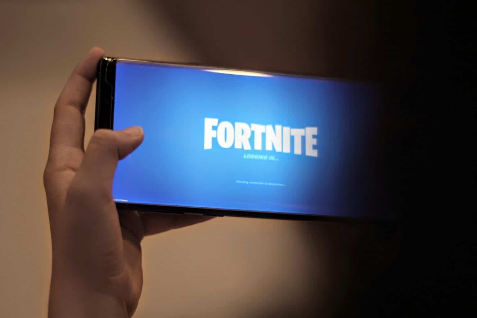 Les différentes étapes à suivre pour télécharger et jouer à Fortnite sur smartphone person holding blue and white box