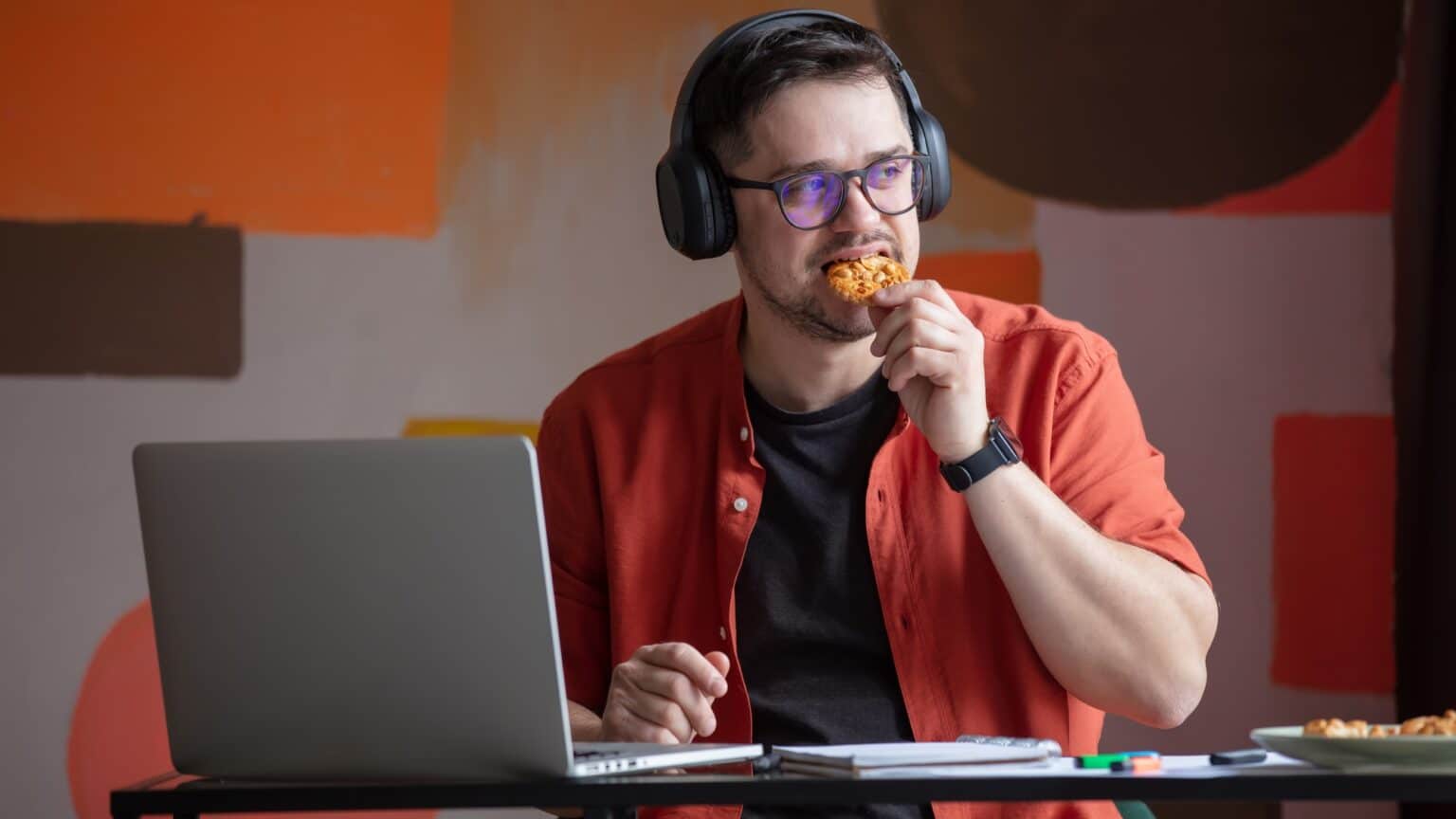 Confidentialité des données et cookies : de quoi s’agit-il ? Man in headphones working in home office and eating a cookie at table