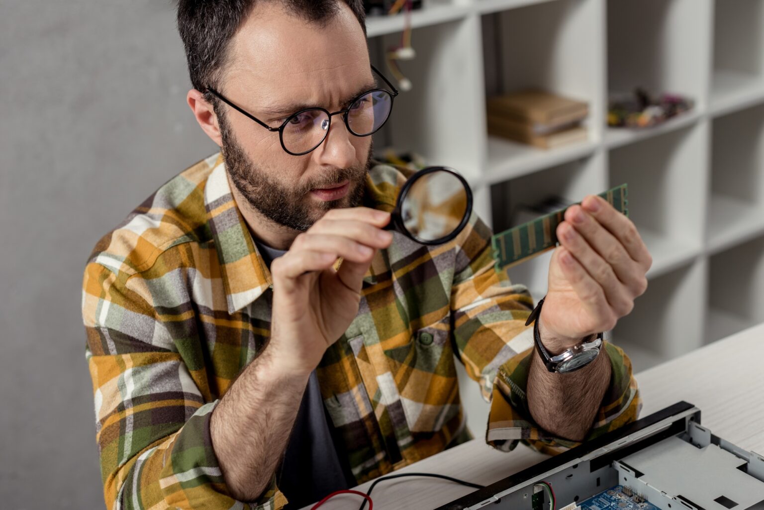 Est-il risqué d’allouer trop de RAM à Minecraft ? repairman looking on ram and using magnifier