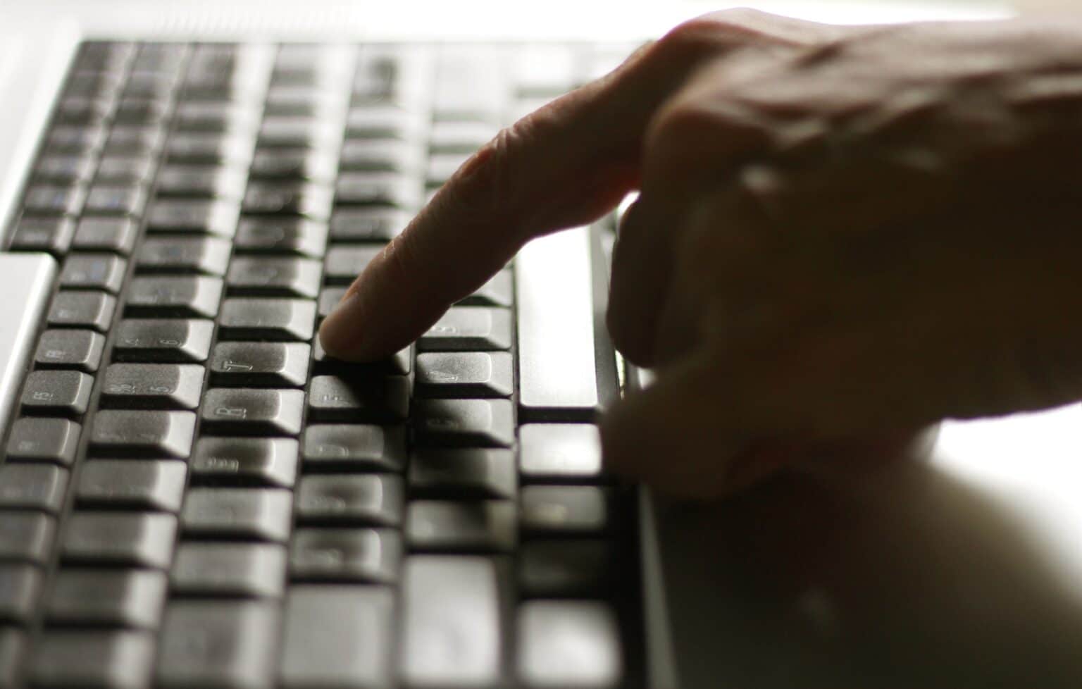 Using laptop, hands typing on the laptop keyboard