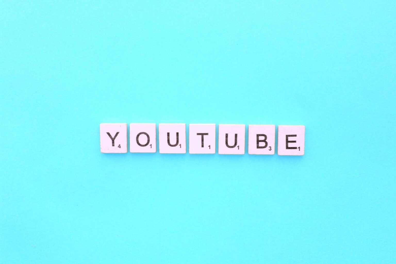 YouTube durcit sa lutte contre les bloqueurs de publicités YouTube scrabble letters word on a light blue background
