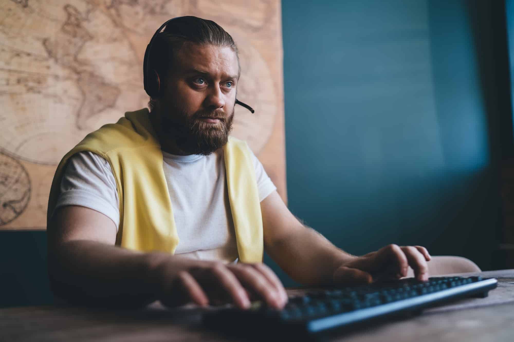 Concentrated male gamer typing on keyboard