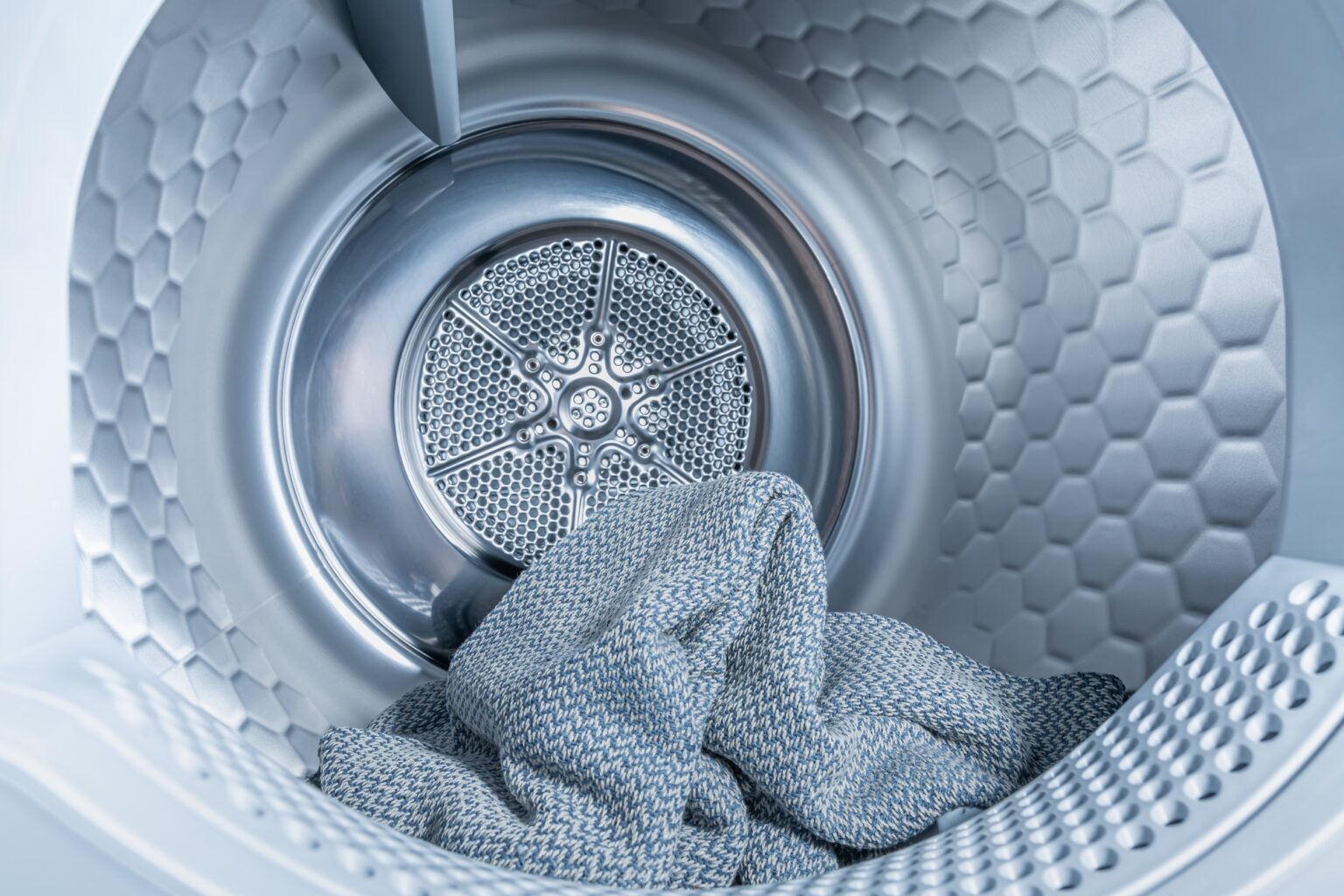 Votre guide ultime pour choisir le sèche-linge parfait Inside of tumble dryer with clean laundry - new generation of heat pump dryer, household concept