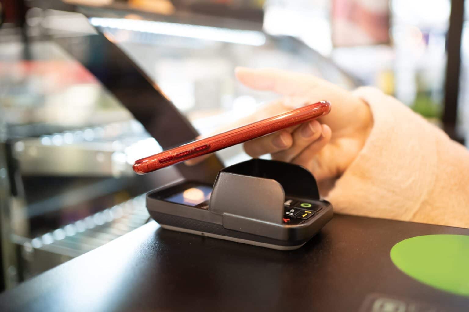 Icône “N” sur votre smartphone Android : Tout ce que vous devez savoir woman paying through smartphone one using NFC technology
