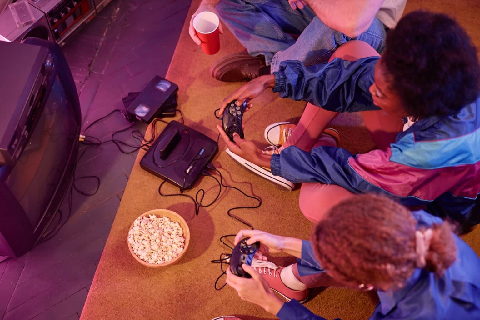 Retroware et Mega Cat Studios dévoilent la démo 8-bit d’Angry Video Game Nerd pour le Steam Next Fest – Essayez-la dès maintenant ! Top view of young people playing retro video game in neon light
