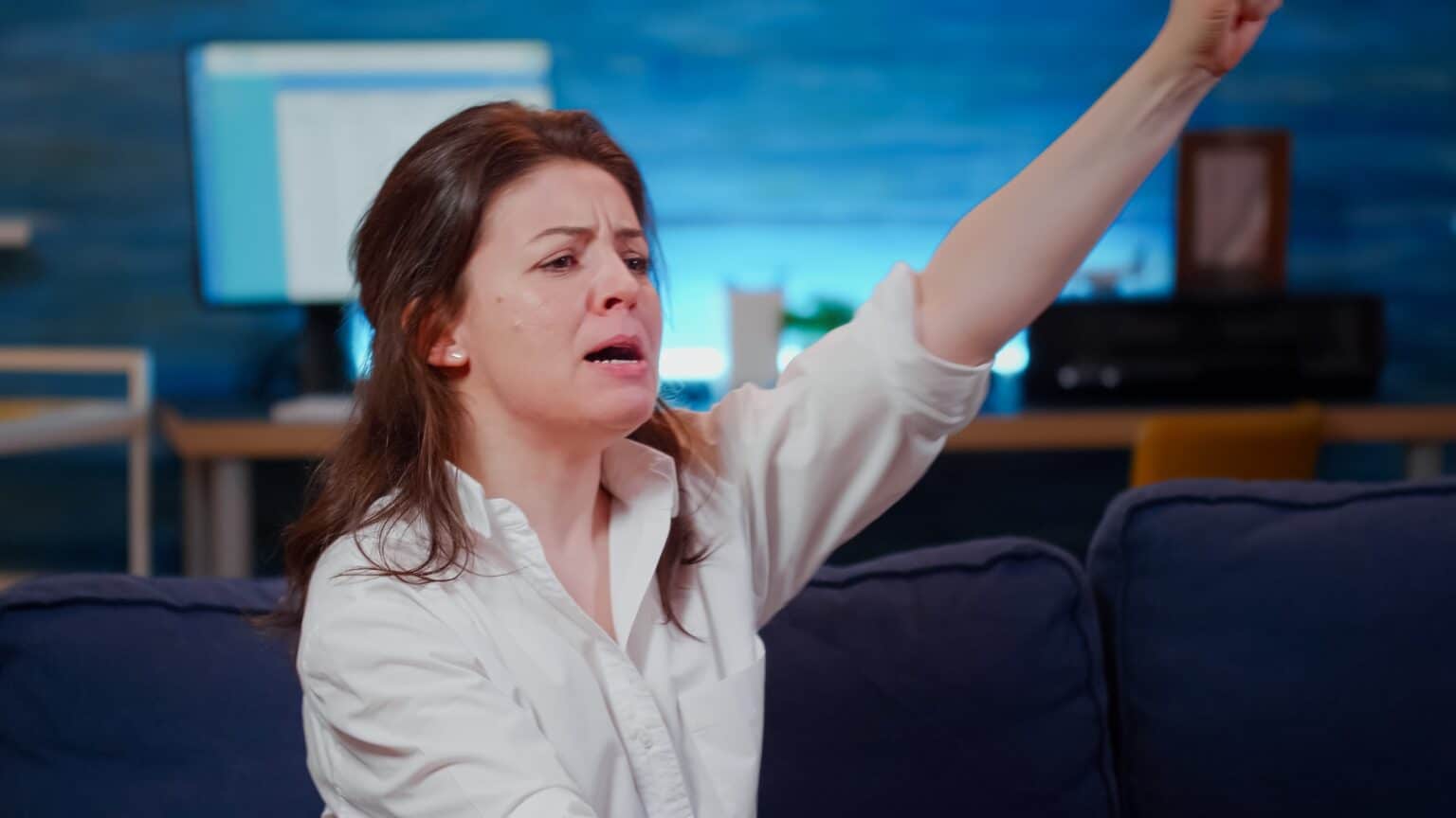 Caucasian woman eating burger and cheering at sport game