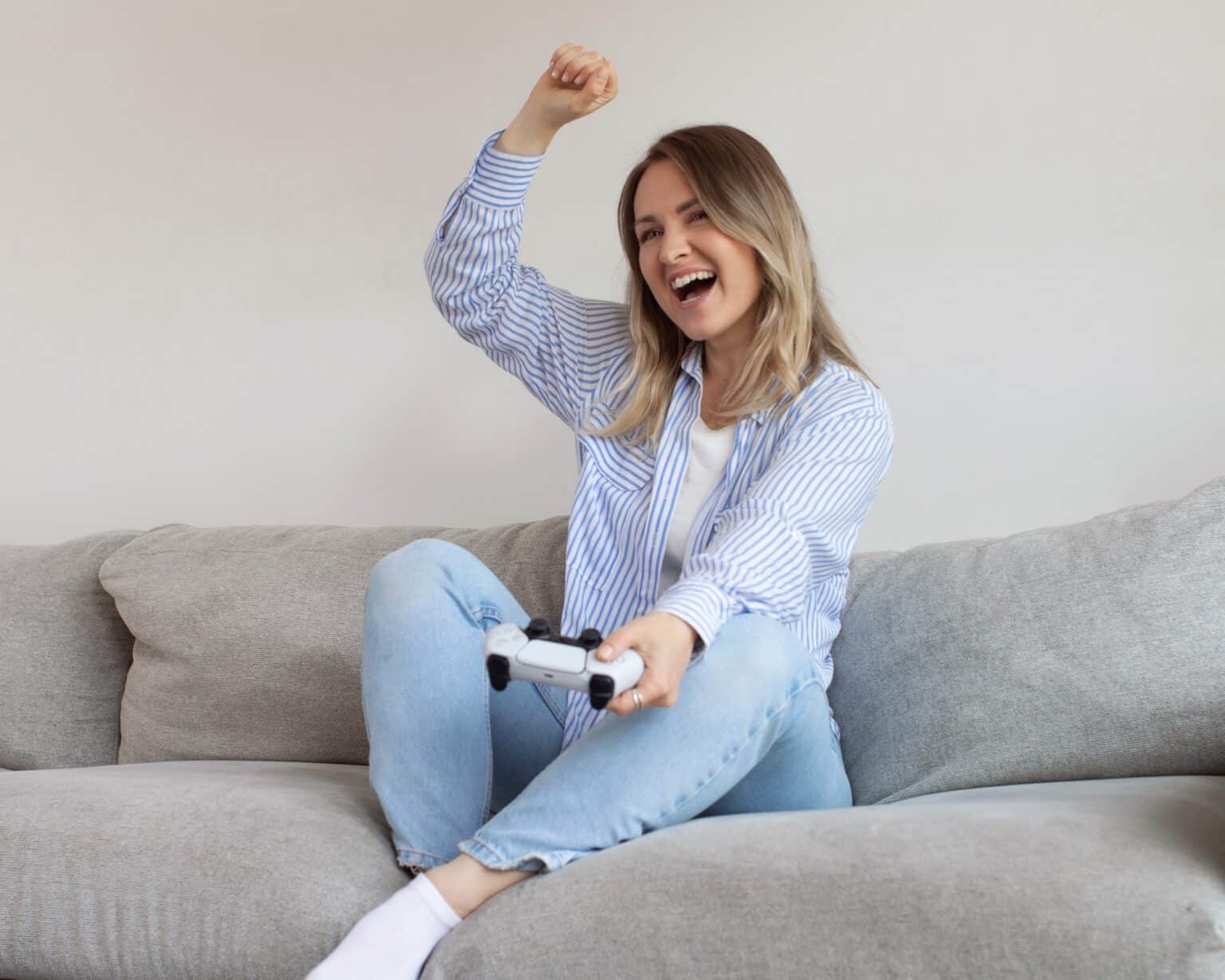 PS5 en 2025 : jeux, ventes, nouveautés et tout ce qu’il faut savoir sur la console de Sony Excited young woman plays videogame in living room