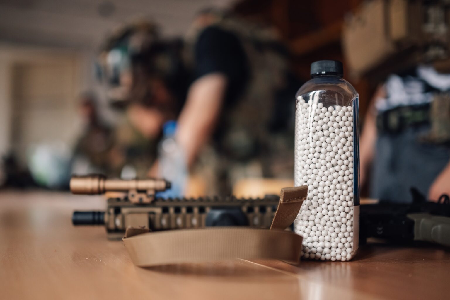 Close up of bottle full of ammo and plastic bullets on table.