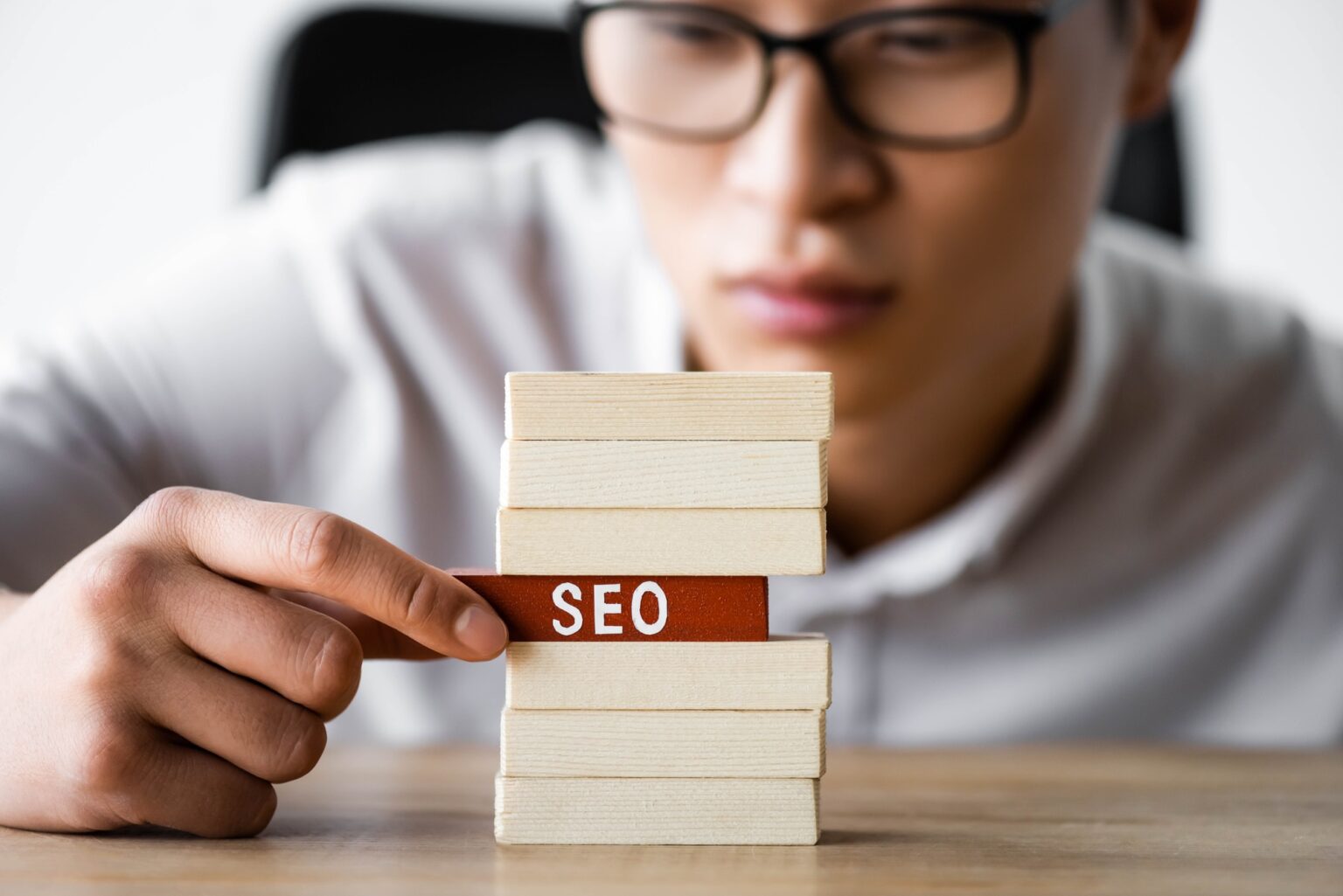 Pourquoi le référencement naturel est vital pour les entreprises locales en 2025 selective focus of asian seo manager holding wooden rectangle with lettering seo